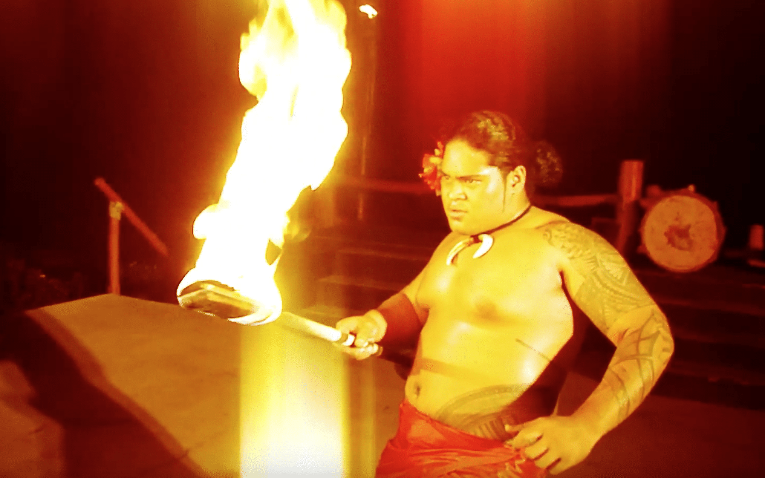 Hawaiian man with tattoos and traditional Hawaiian lava-lava attire, preforming the ceremonial fire knife dance at the Bobrick Fire & Knife Convention (video production by Merging Media).