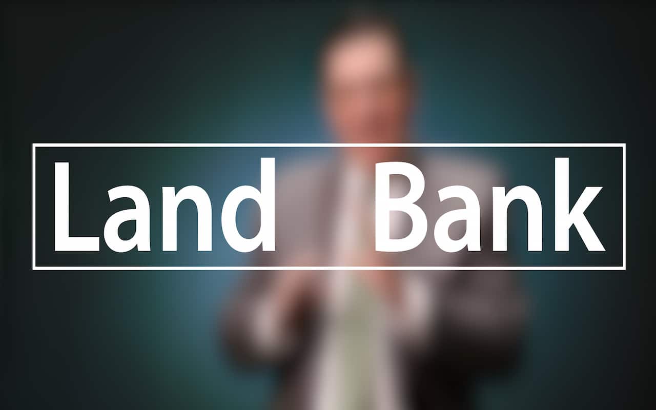 Mayor Peduto Landbank Campaign; Blurred figure of a man in a suit sitting in front of a very dark blue background, the large word in the foreground in white text reads; Land Bank (video produced by Merging Media).