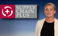 Commerical for Paper Products Supply Chain Plus a young woman with blonde pony tail wearing a cream blazer over a black top stand to the right of a sign that reads; SUPPLY CHAIN PLUS (video production by Merging Media).