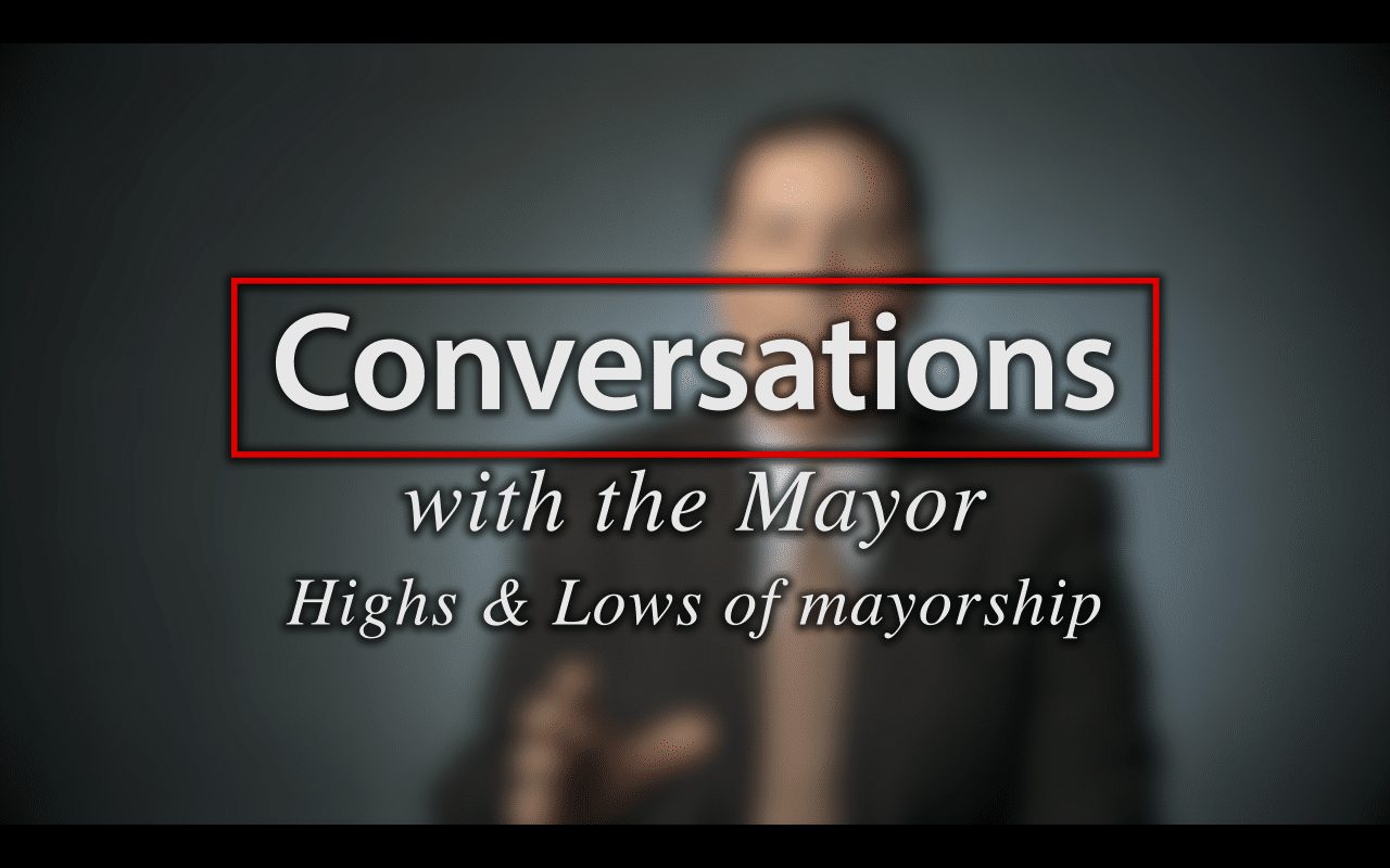Mayor Peduto talks Mayorship; Blurred figure of a man in a suit sitting in front of a very dark blue background, the large word in the foreground in white text reads; Conversations with the Mayor, Highs and Low of Mayorship (video produced by Merging Media).