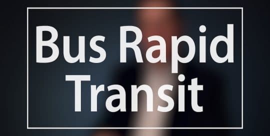 Mayor Peduto Bus Rapid Transit campaign; Blurred figure of a man in a suit sitting in front of a very dark blue background, the large word in the foreground in white text reads; Bus Rapid Transit (video production by Merging Media).