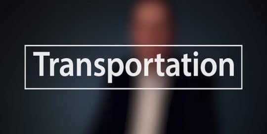 Blurred figure of a man (Mayor Peduto) in a suit sitting in front of a very dark blue background, the large word in the foreground in white text reads; Transportation (video production by Merging Media).